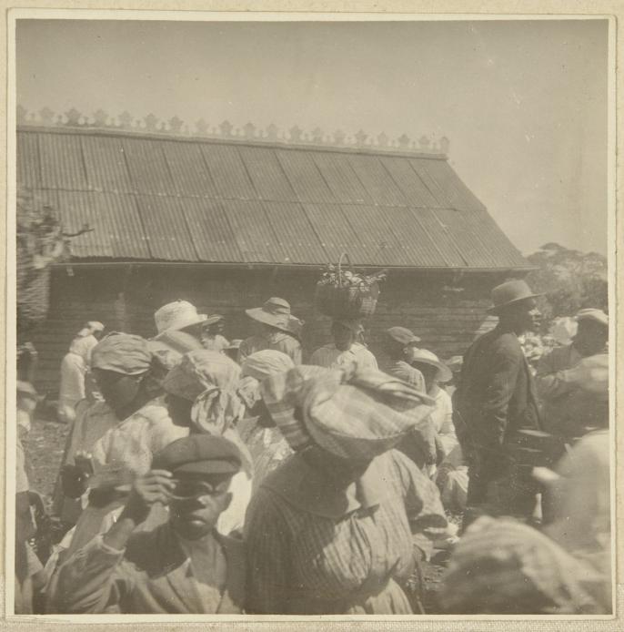 Unknown photographer, Boy with optical device at market, location unknown, c. 1915.
