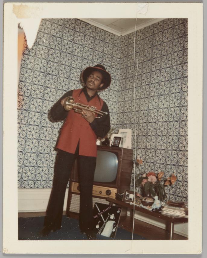 Polaroid of man holding a trumpet