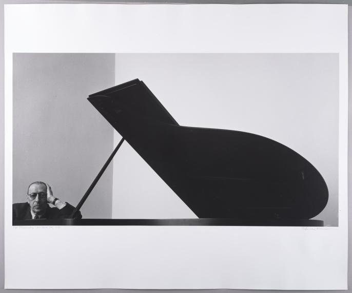 The famous Stravinsky portrait. Stravinsky sits at a piano.