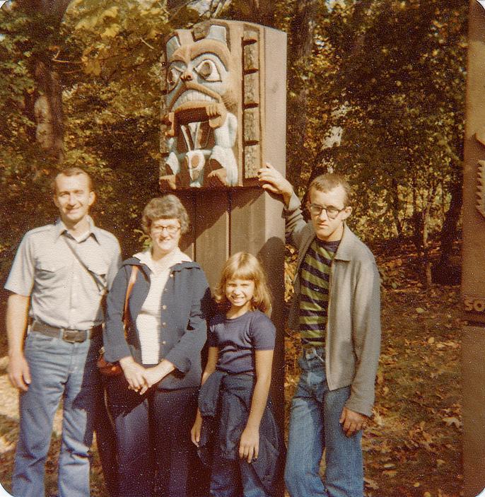A photo of Keith, his parents, and Kristen beside a statue