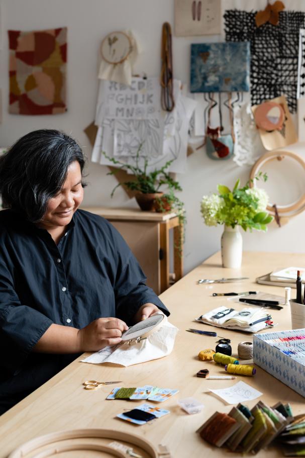 An image of Arounna Khounnoraj embroidering