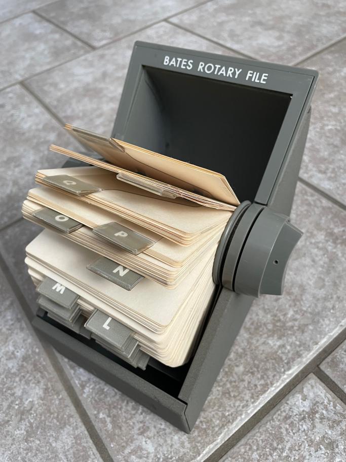 An image of an old-school grey Rolodex. It has Bates Rotary File written on the top in white text.