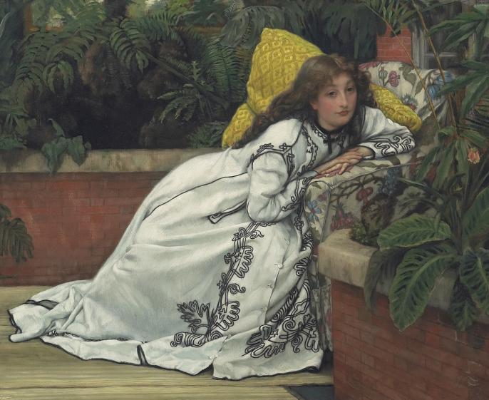 Woman in white dress featuring black embroidery lounging in a conservatory surrounded by tropical plants