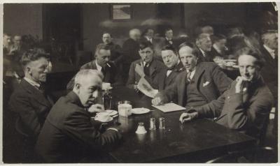 A black and white photograph of members of the Group of Seven seated around a table looking at the camera
