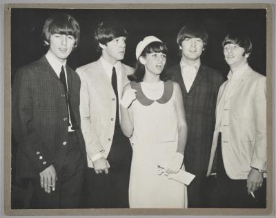A photo of Trudy Medcalf standing in the centre of all four Beatles members.