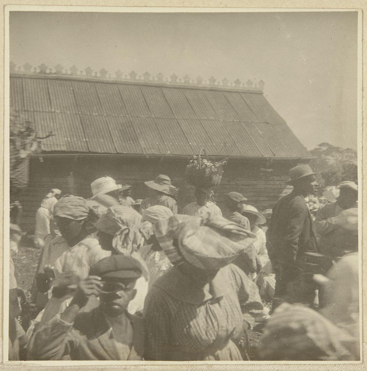 Unknown photographer, Boy with optical device at market, location unknown, c. 1915.