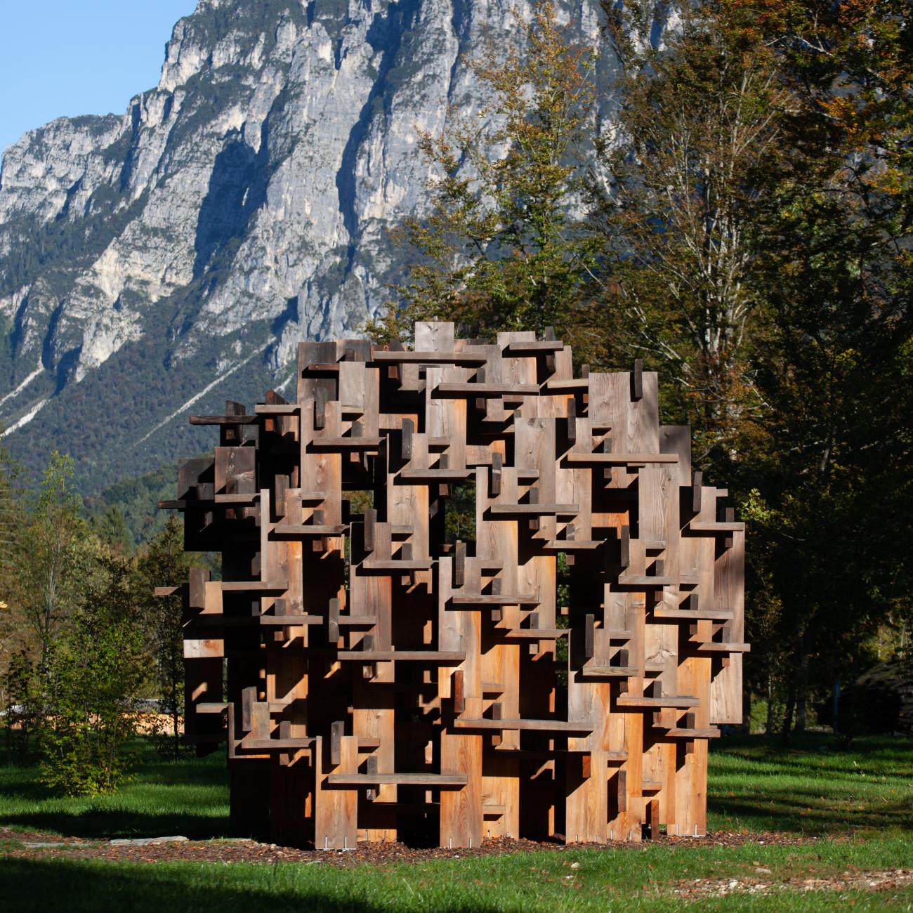 Wooden sphere set against mountain backdrop