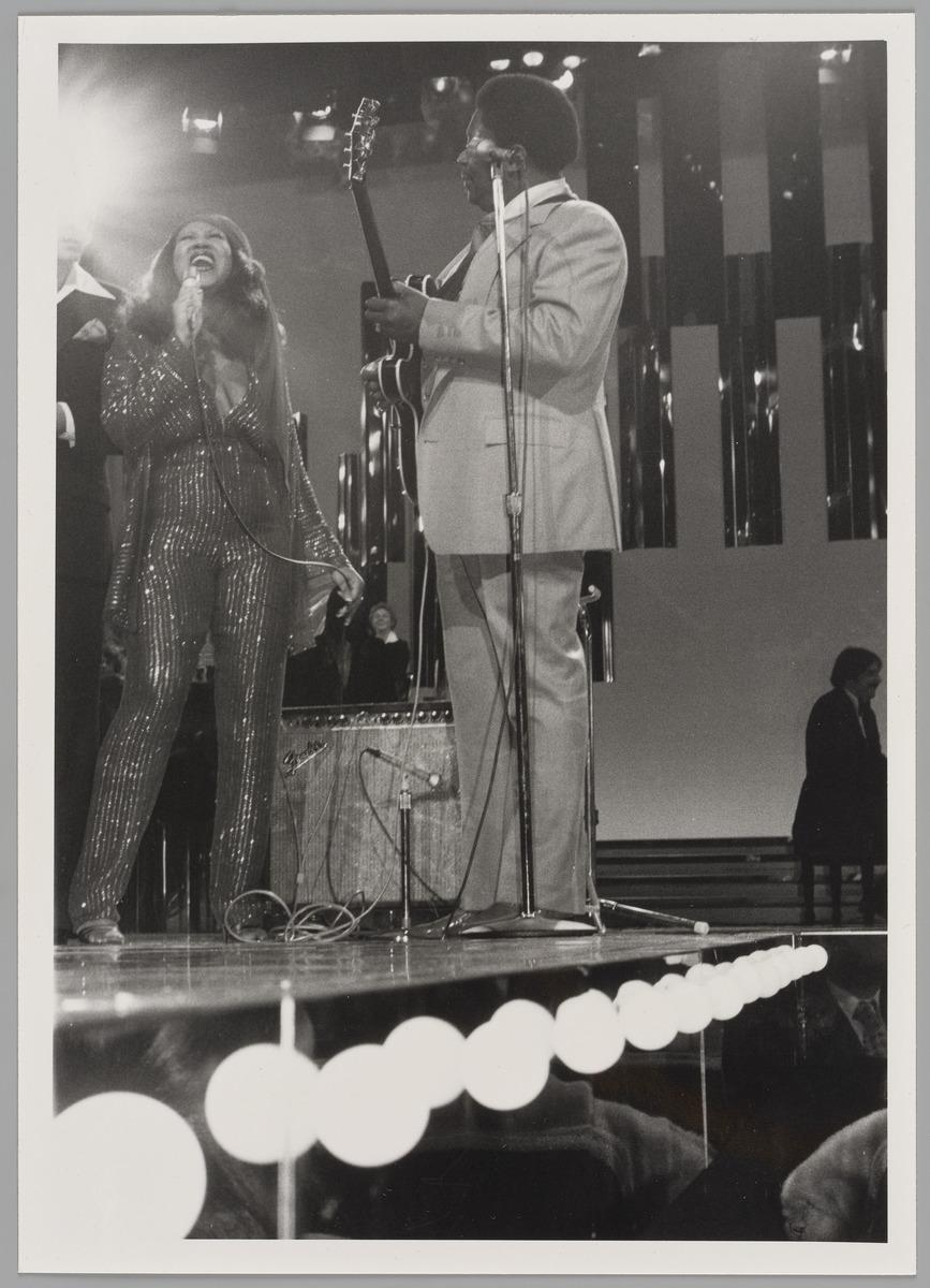 A photograph of singers Aretha Franklin and B.B King performing on stage in Hamilton, Ontario. Aretha is singing and B.B king is playing the guitar facing her