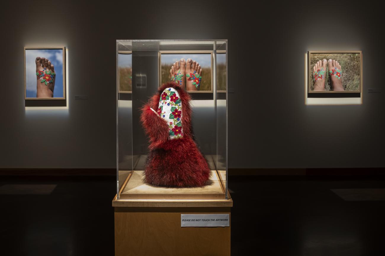 An image of a glove covered in red fur. The inside of the glove is covered in intricate beading of red flowers