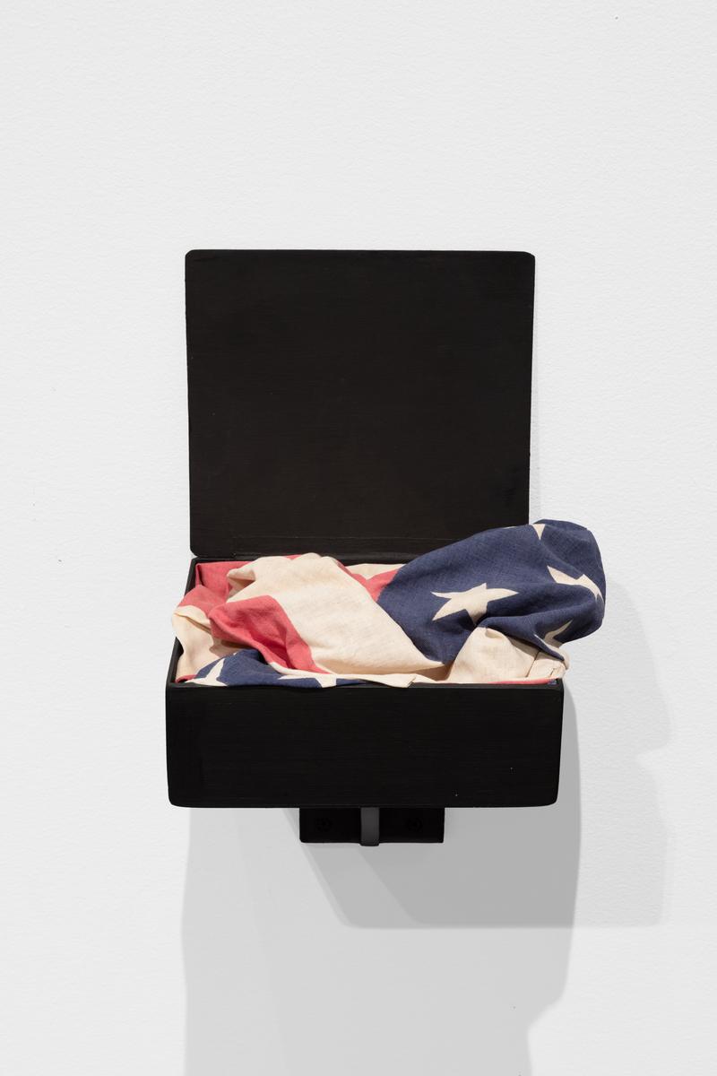 The American flag folded in a small wooden box