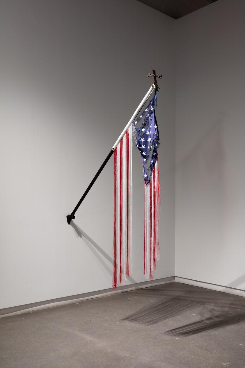 An American flag with rips and unravelling threads