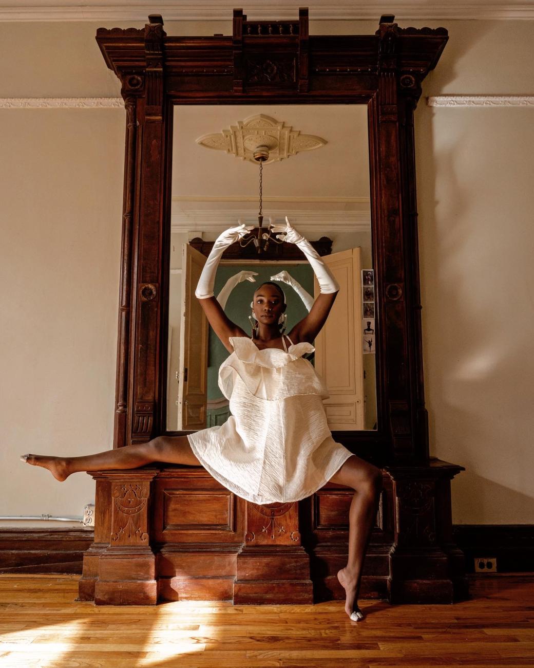 A photograph of Jordan Peterson posing on a dresser, dressed in all white
