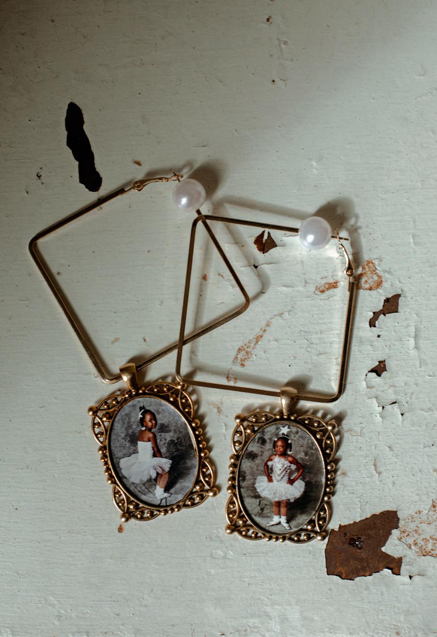 A close-up of Jordan Peterson's earrings with childhood dance photos on them