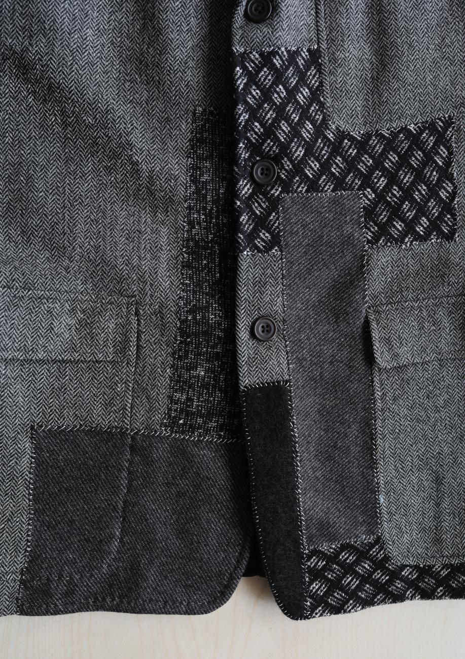 A close-up photograph of a blazer with various patching on it