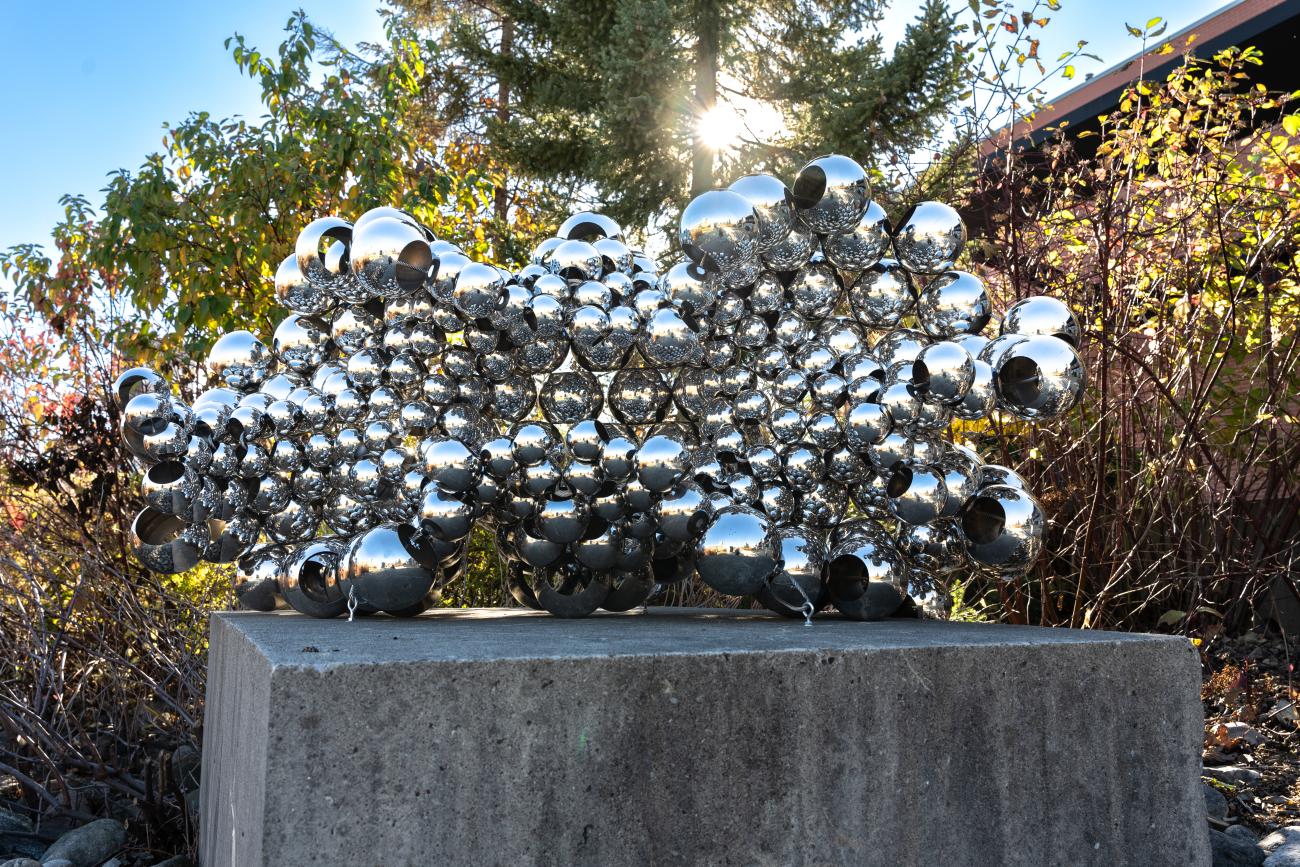 An image of Sharl G. Smith's sculpture Embrace II. The sculpture is made with large, silver beads