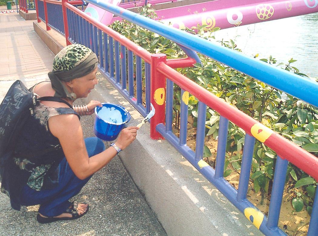 An image of Pacita Abad painting the Alkaff Bridge in Singapore.
