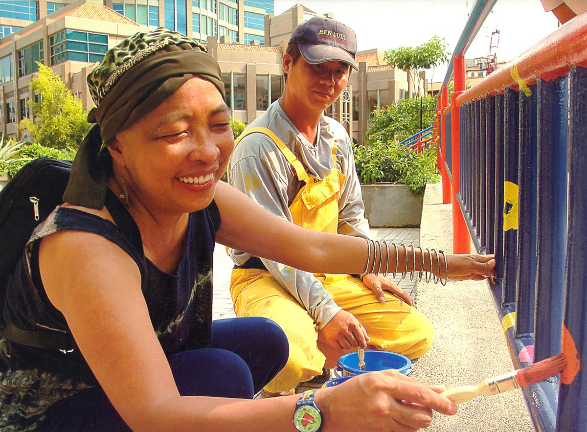 An image of Pacita Abad painting the Alkaff Bridge in Singapore.