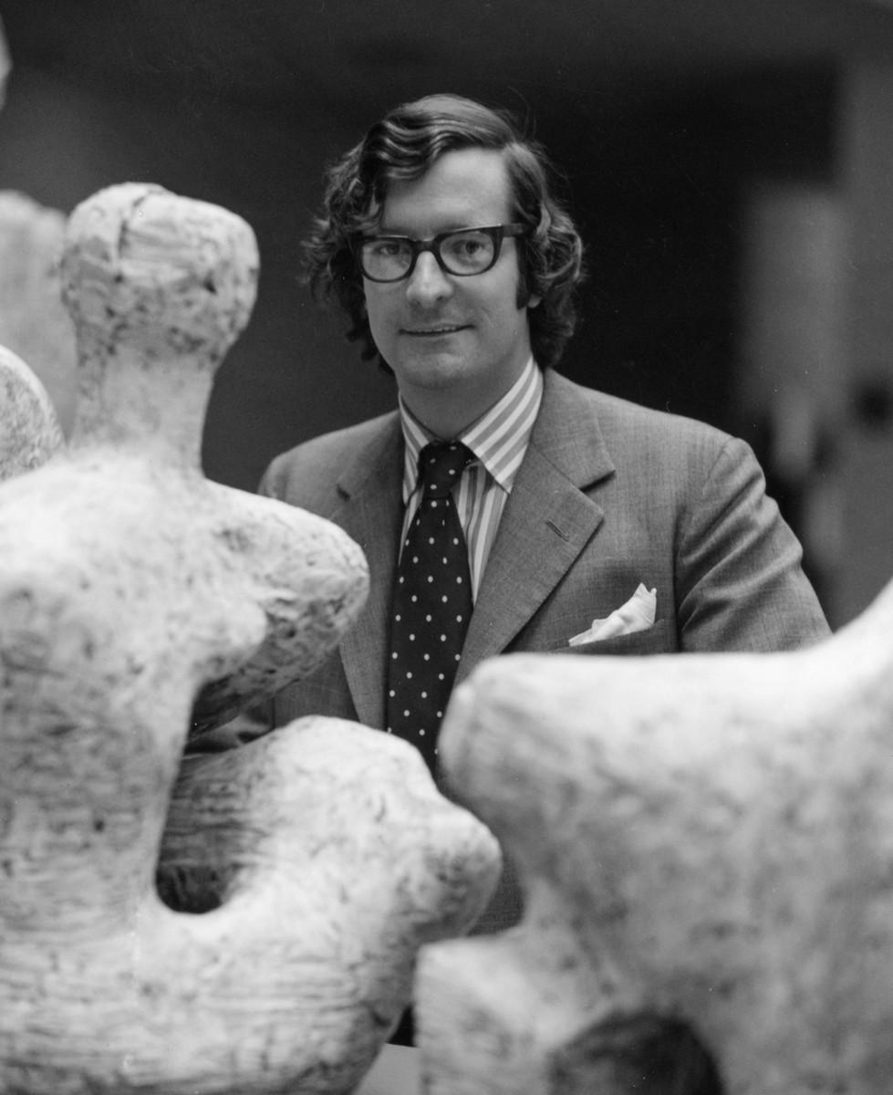 Alan Wilkinson in the Henry Moore Sculpture Centre. A man wearing glasses stands beside sculptures made of plaster.