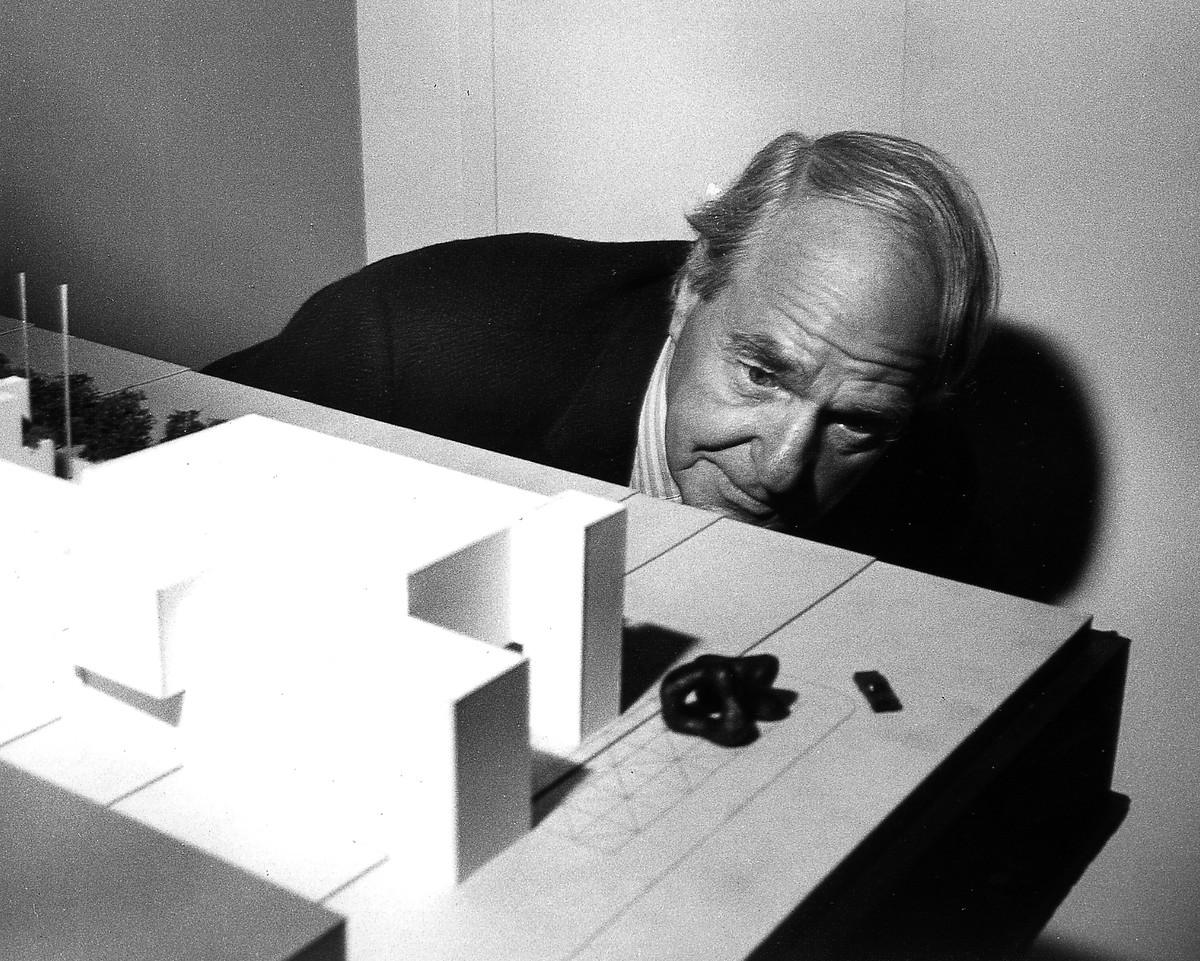 Henry Moore inspecting a model of the expanded Art Gallery of Ontario with Large Two Forms (1966 -1969), positioned outside, Toronto, October 1971.