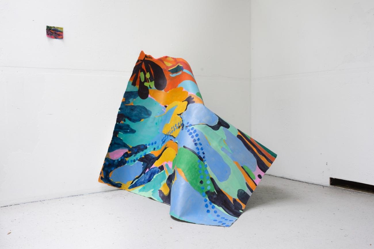 An image of Maru Aponte's work Miss Palomar. The work comes out of the wall and rests on a found beach chair.