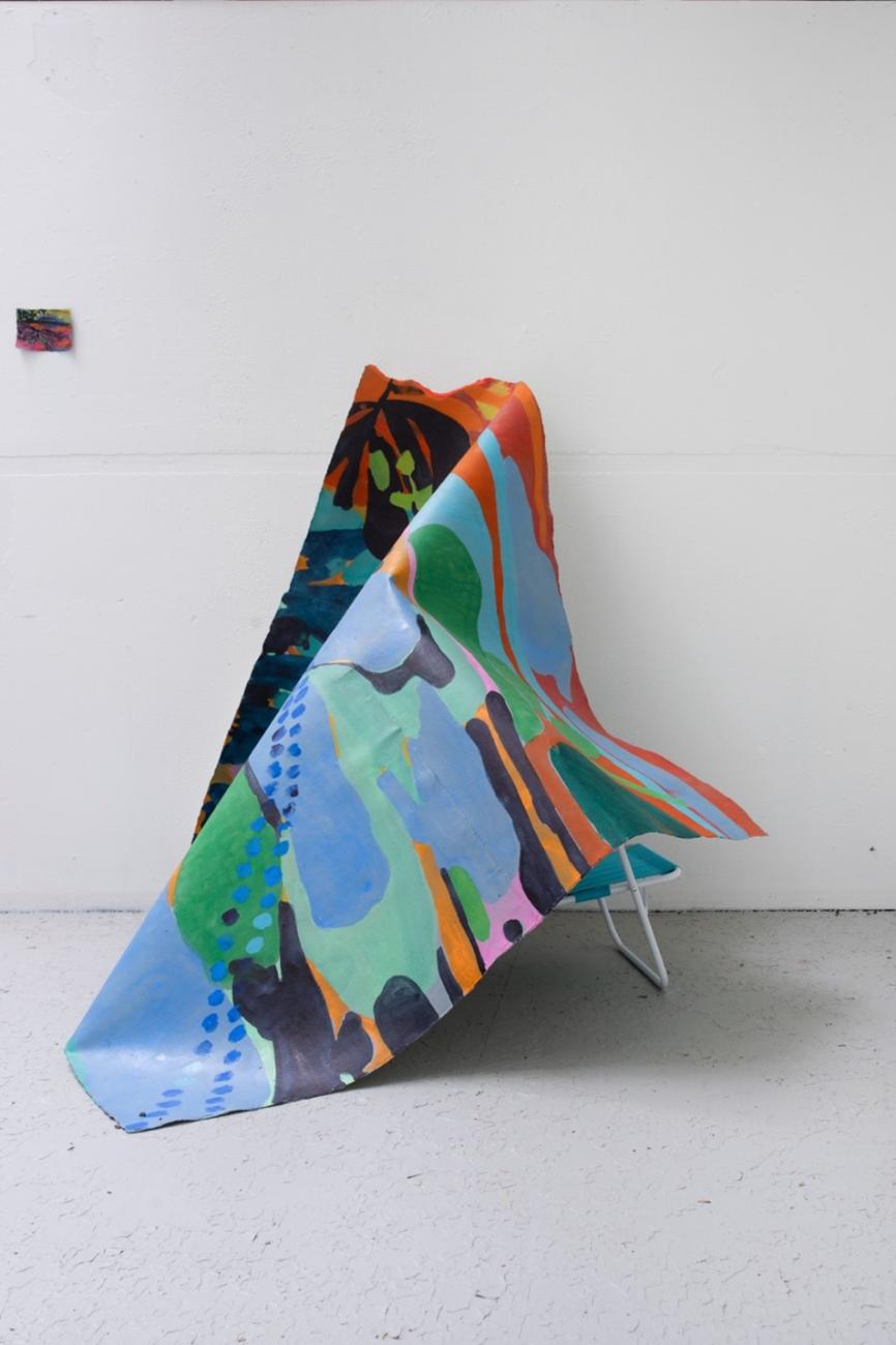 An image of Maru Aponte's work Miss Palomar. The work comes out of the wall and rests on a found beach chair.
