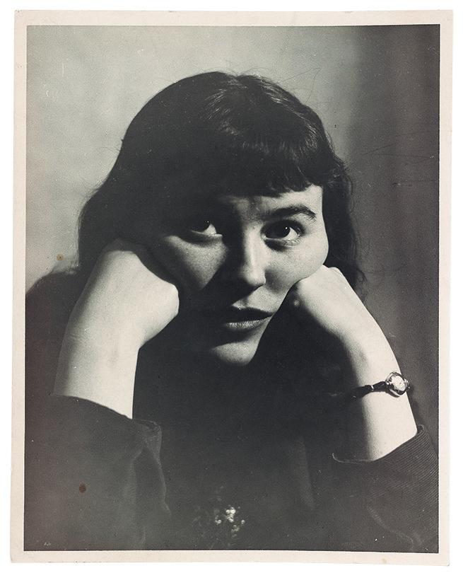 A black and white photograph of Joyce Wieland. She rests both her cheeks on her hands