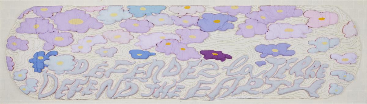 An image of Joyce Wieland's quilt Defend the Earth. It features pastel purple, pink, and blue flowers with the phrase "defend the earth" in English and French