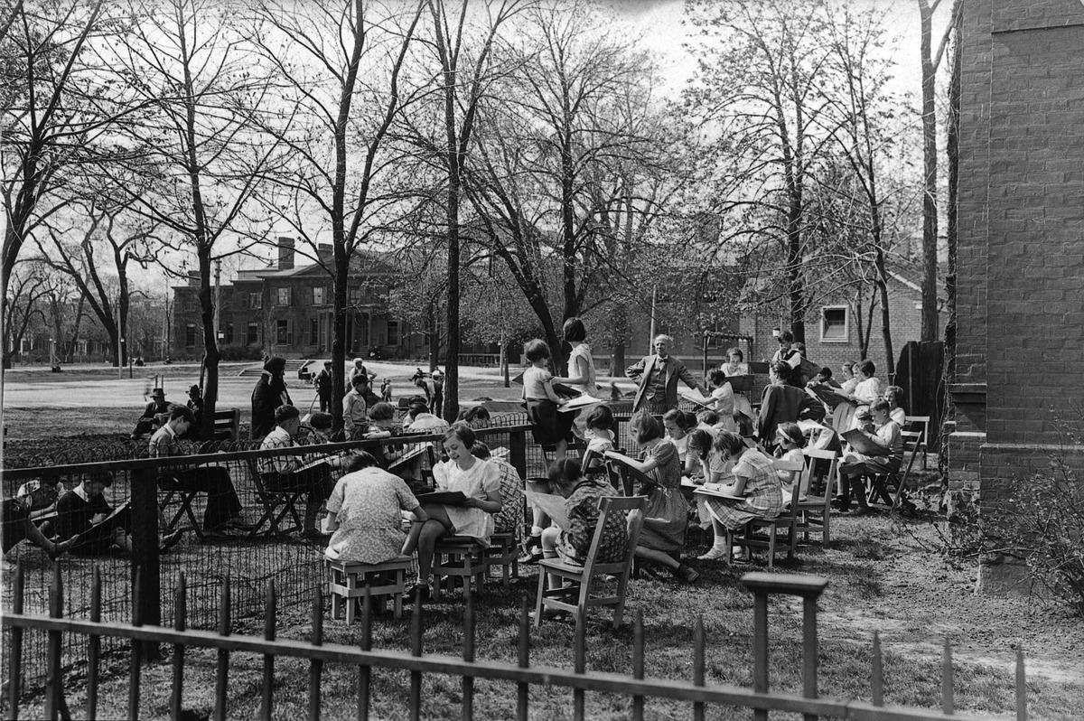 An image of Arthur Lismer teaching a children's sketching class outdoors in Grange Park