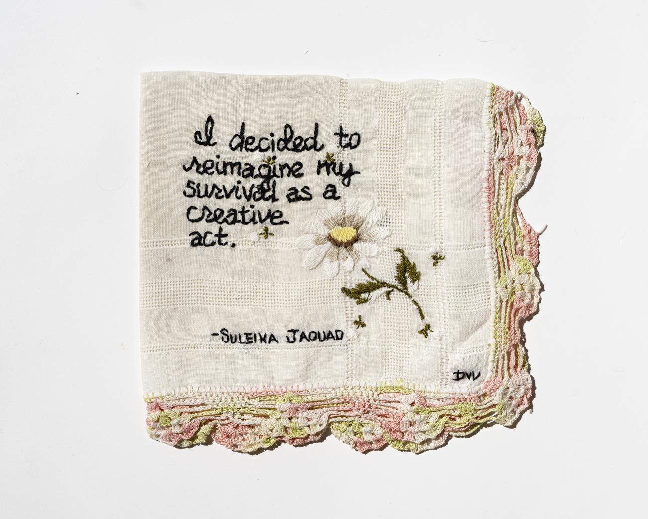 A quote from writer Suleika Jaouad is stitched onto a folded textile with light pink and green trim around the edge. The quote reads &quot;I decided to reimagine my survival as a creative act.&quot;