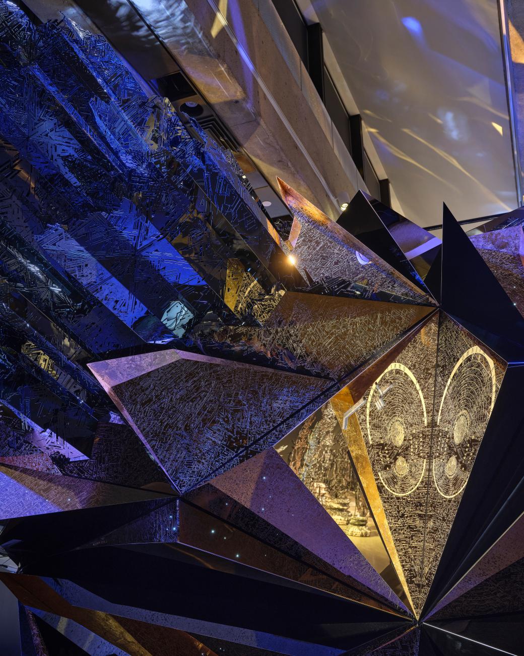 A detail image of Ranbir Sidhu's sculpture Asteroid 3033 X1, which highlights inscriptions on the panels of the work