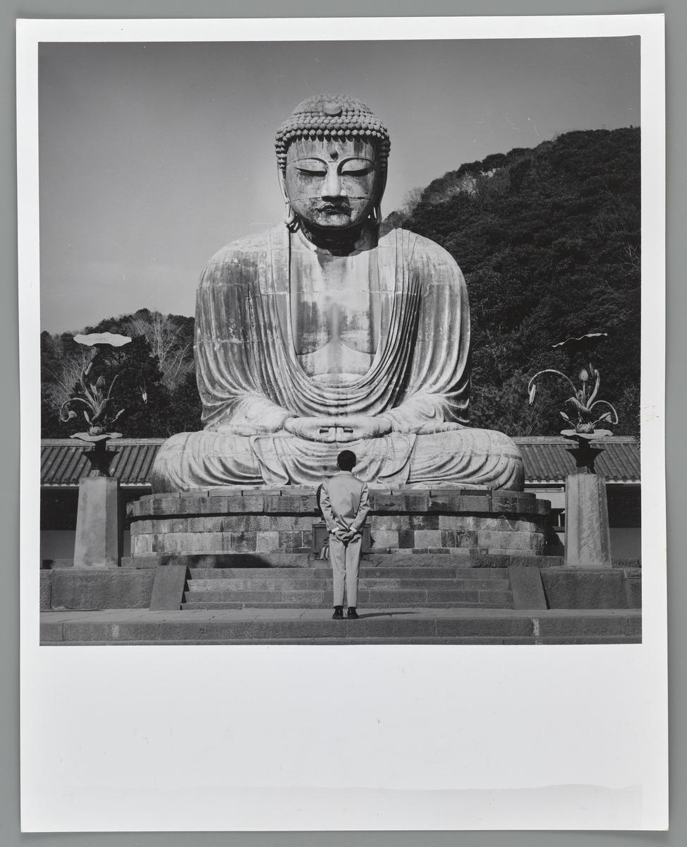 Tseng Kwong Chi's photograph, Kamakura Japan. The photo depicts a large Buddhist statue with a person standing in front of it.