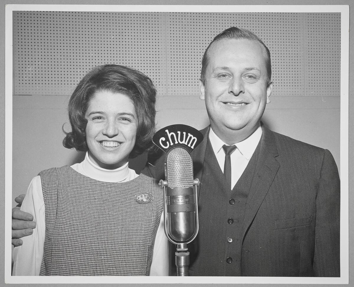 A photo of Trudy Medcalf at Chum Radio. She stands beside a man who puts his arm around her.
