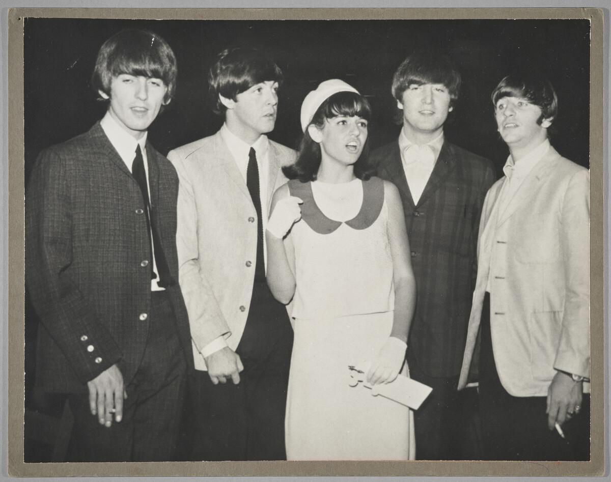 A photo of Trudy Medcalf standing in the centre of all four Beatles members.