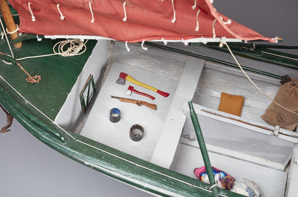 A detail shot of Angus Trudeau's boat model Red Sailboat. It shows tiny axes, a musket, and pails inside the boat.