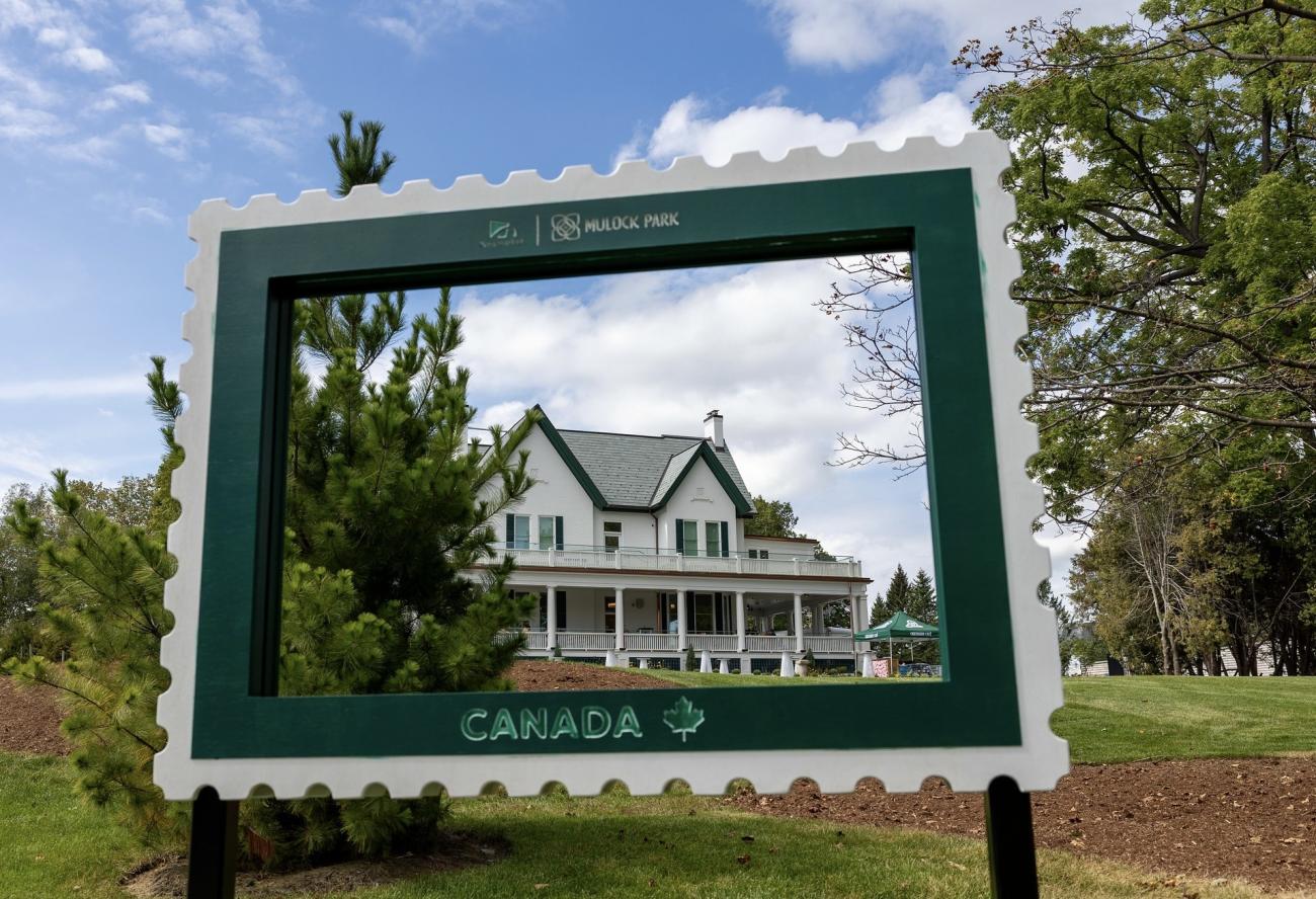An image of Mulock House taken through a stamp frame outside the house.