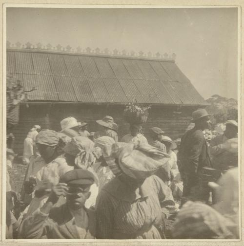 Unknown photographer, Boy with optical device at market, location unknown, c. 1915.