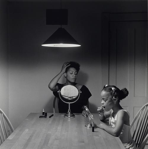 A Black and White photo oh a mother and her daughter at a table, applying makeup 